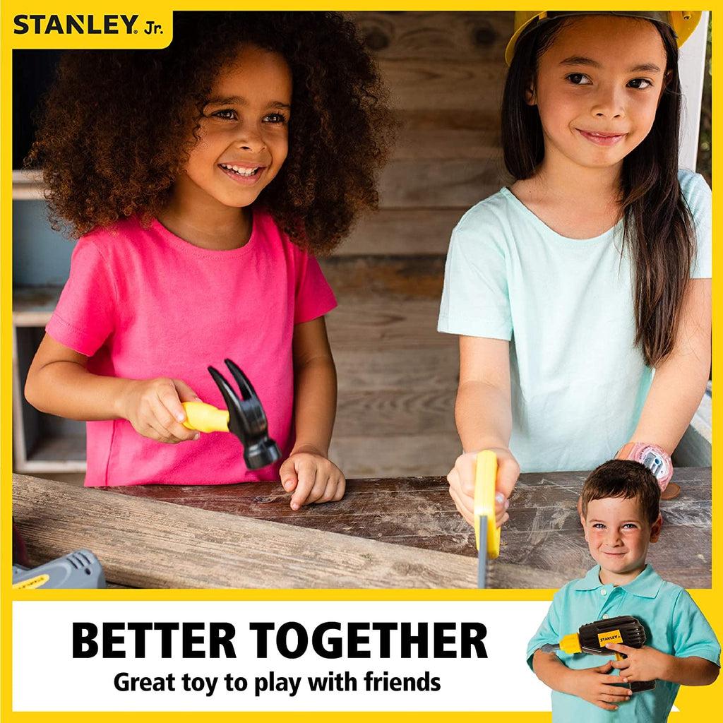 Scene of two young girls smiling while they use the play tools together.