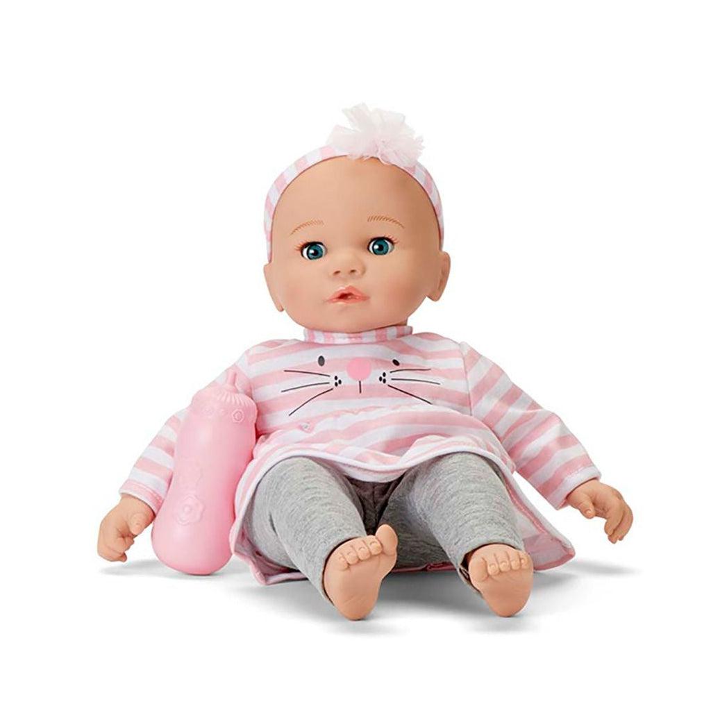 The baby doll is shown from the front. It has a bald head, a long sleeved shirt with pink and white horizontal stripes and a kitty nose, eyes, and whiskers on the front. it also has grey tights and a stripped headband and a pink baby bottle