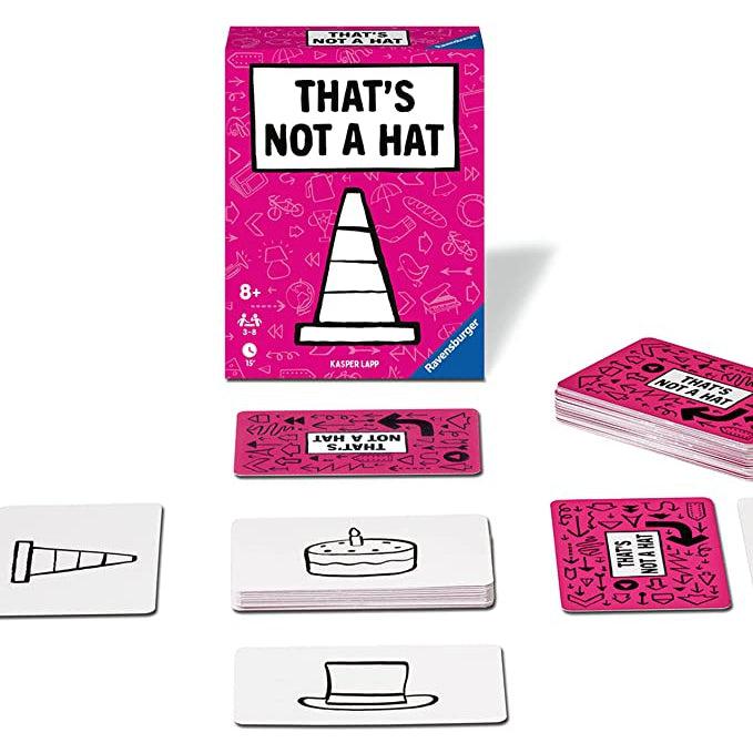 The box is shown behind the game being played. There are 6 piles of cards with 5 being arranged with one in the center and one stack on each side. Three of the stacks have face up cards showing a trafic cone, a hat, and a cake.