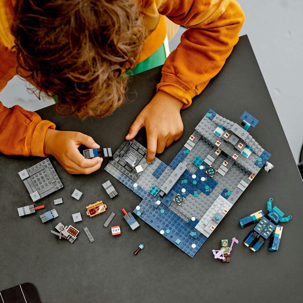 A top down image of a child roughly half way through building the set.