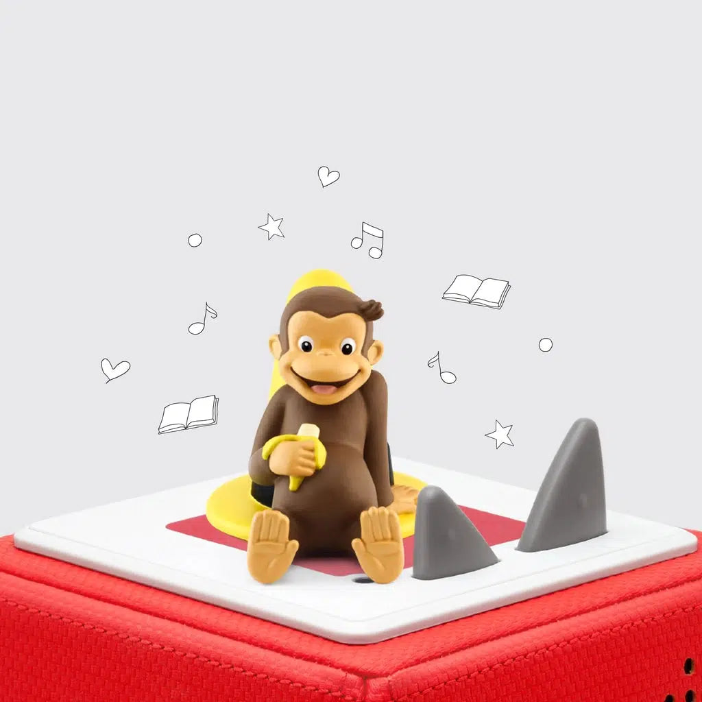 The tonie is a figurine of curious george, a small brown chimp/monkey, leaning against a tall yellow hat with a wide brim and holding most of a banana
