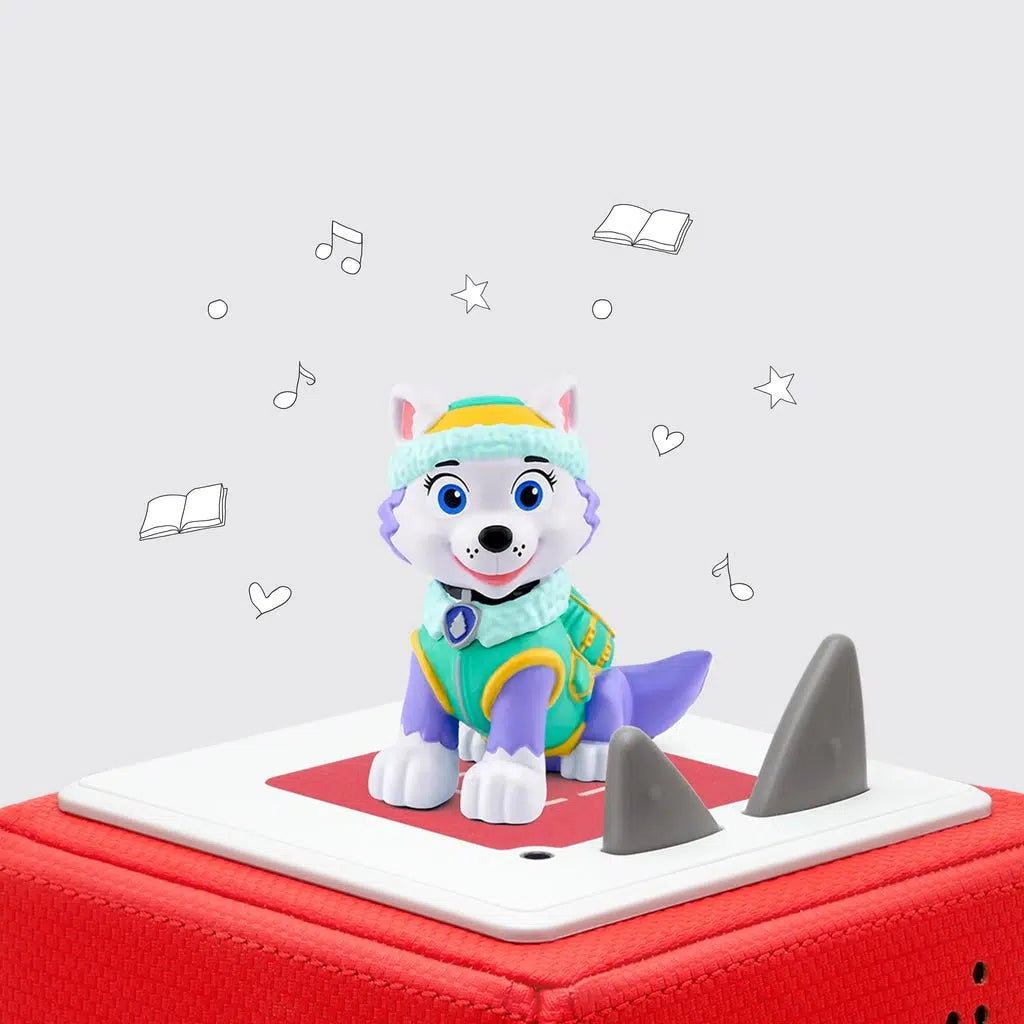 Everest tonie on a red tonie box | tonie is a purple furred husky dog with white face, ears, and paws, and is wearing a green coat, hat, and backpack