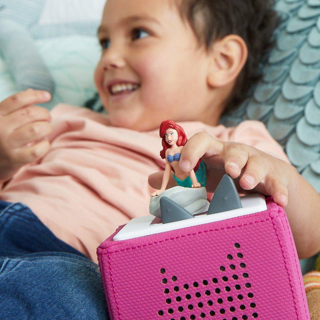 a child is holding the little mermaid on a box so she will play music to listen to