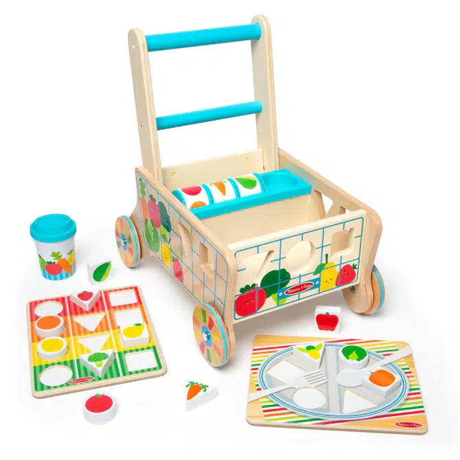 Image of the fully put together cart outside of the packaging. The set includes the wooden grocery cart, a plate board, a color sorting board, a cup, and many different wooden fruits and vegetables of all different shapes.