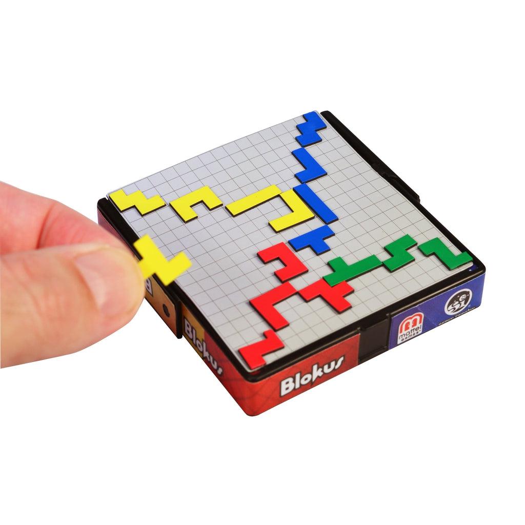 Shows a hand placing a game piece on the board for size comparison. The board is about the size of a child's palm.