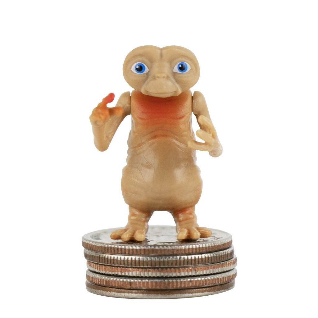 Close up of ET standing on a stack of quarters. It is very detailed with painted blue eyes and a red tinted chest and finger.