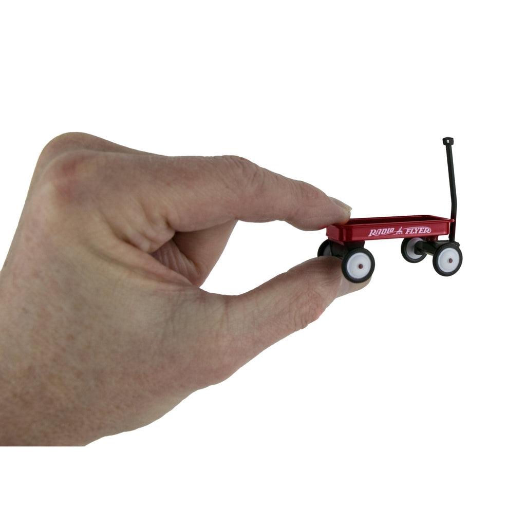 Shows hand holding Radio Flyer wagon. The wagon is about the size of a thumb.