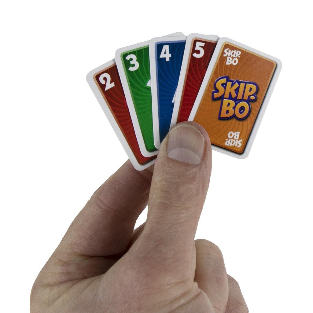 Shows a hand holding five of the Skip-Bo cards. Each card is about the size of a thumb.